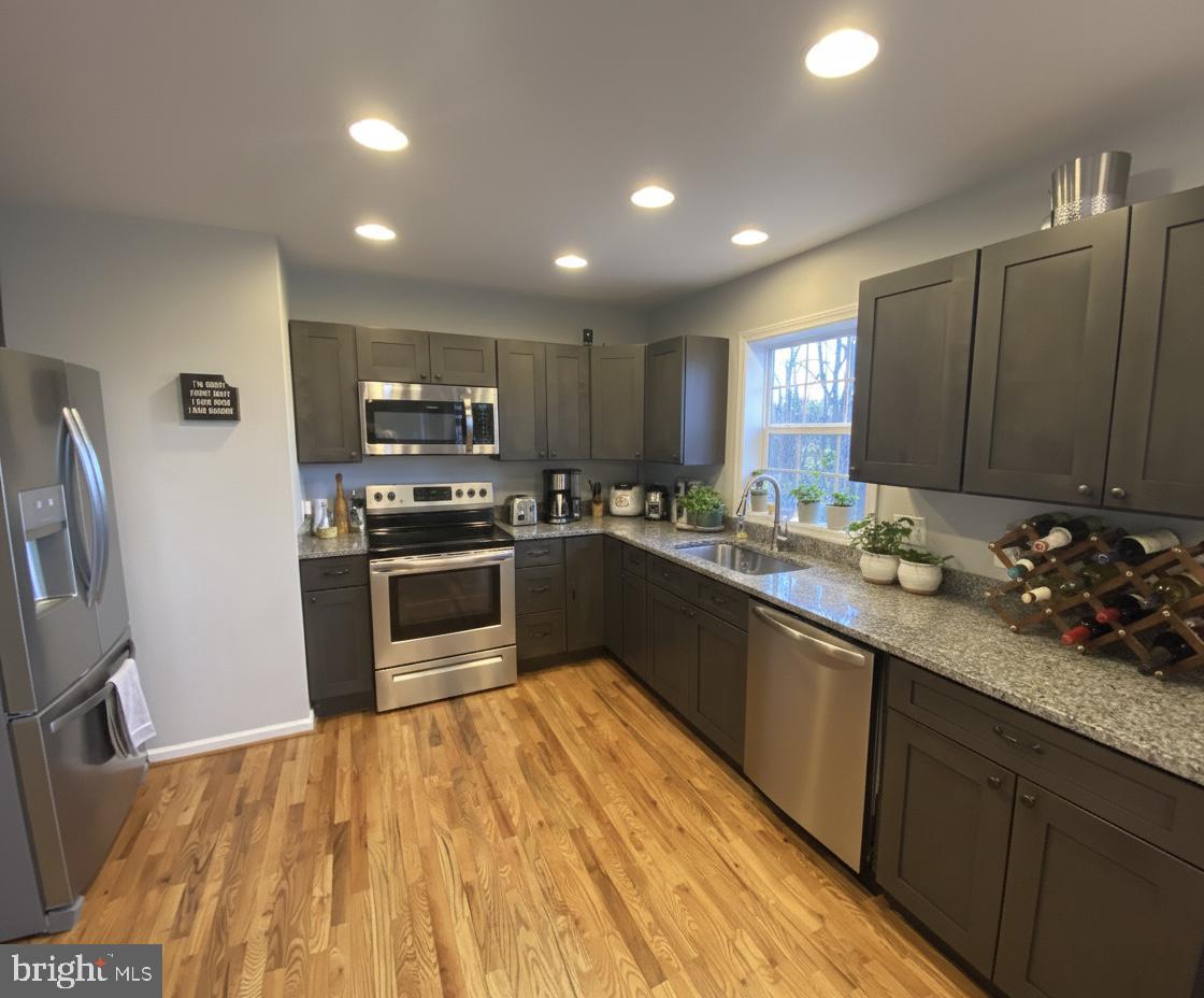 397 Parkside Road Linden, VA 22642 - Photo 8 of 32 a kitchen with stainless steel appliances a sink dishwasher a refrigerator a microwave oven with cabinets and wooden floor