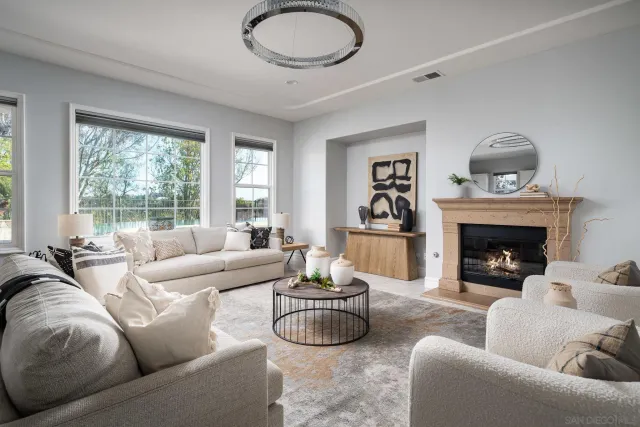a living room with furniture a fireplace and a large window