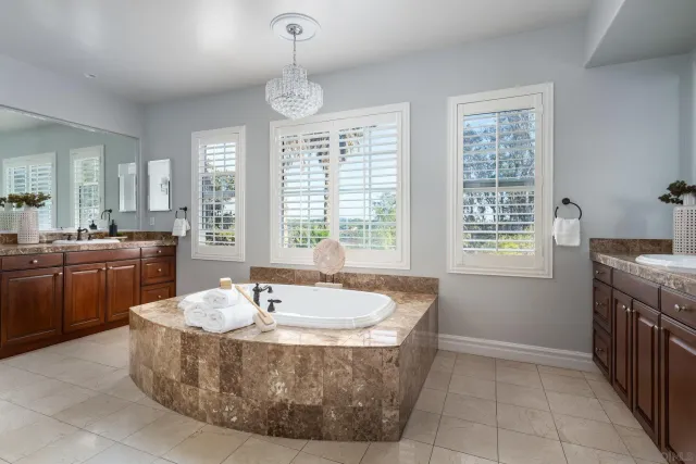 a spacious bathroom with a tub sink and mirror