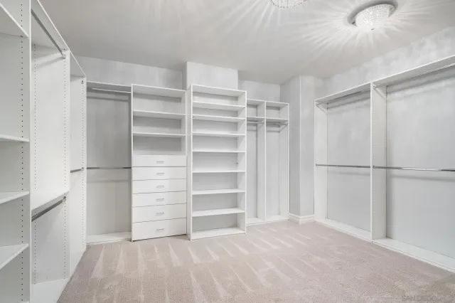 a view of walk in closet with empty racks