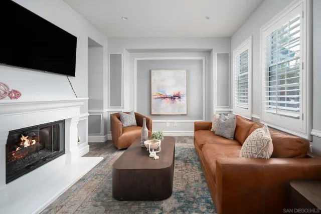 a living room with furniture a flat screen tv and a fireplace