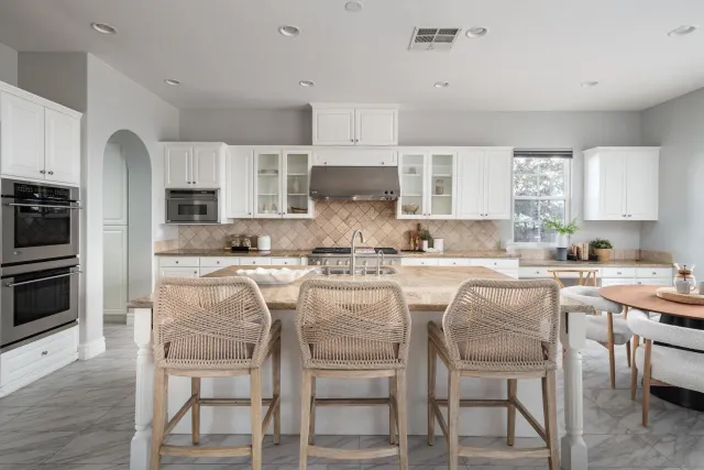 a kitchen with kitchen island granite countertop a table and chairs in it