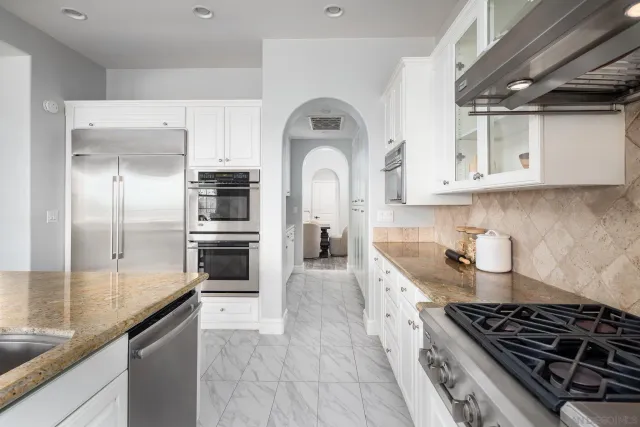 a kitchen with stainless steel appliances granite countertop a stove and a refrigerator