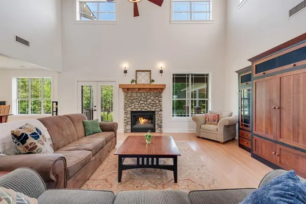 a living room with furniture large window and a fireplace