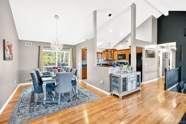 a dining room with furniture a chandelier and wooden floor