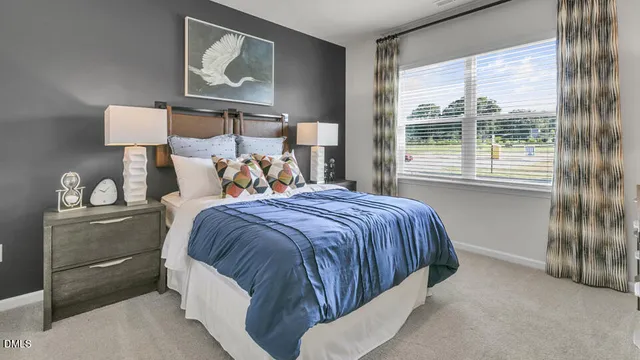 a bedroom with a bed a mirror on dresser and a wooden floor