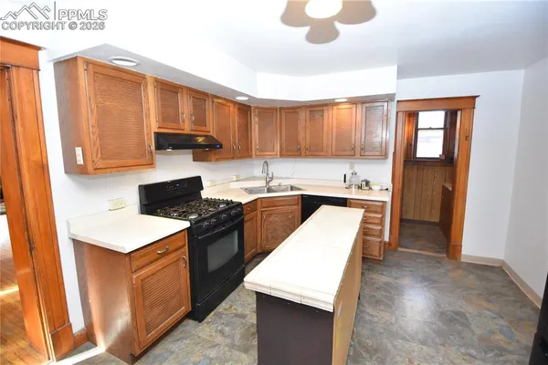 a kitchen with stainless steel appliances sink stove and cabinets