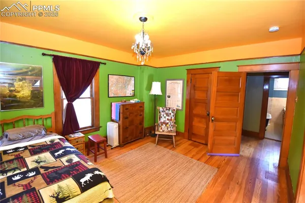 a living room with furniture a dining table wooden floor and a fireplace