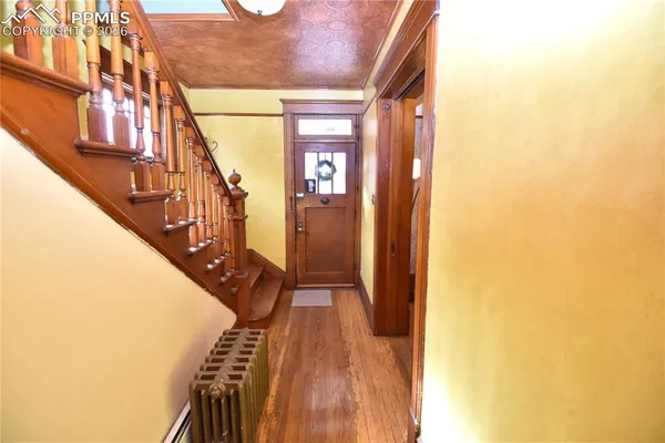 a view of a hallway with wooden floor and staircase
