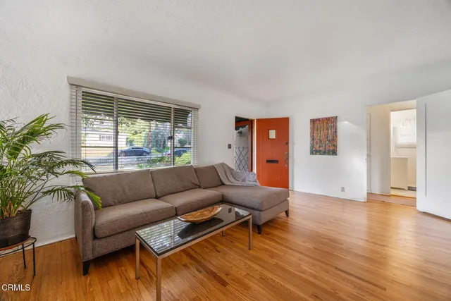 a dining room with furniture a chandelier and wooden floor
