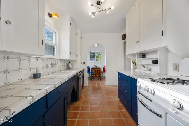 a white kitchen sink sitting next to a white cabinet