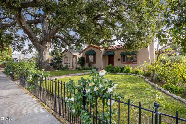 a front view of a house with yard and green space