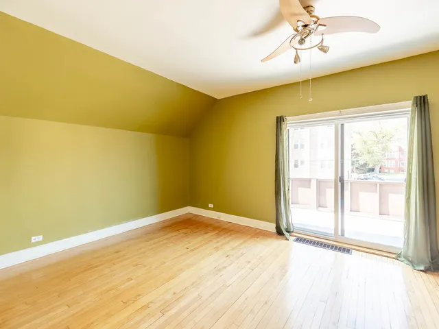 a view of empty room with a window and wooden floor