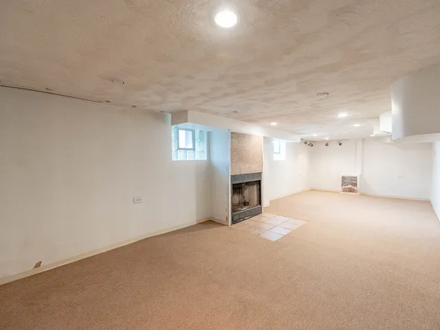 an empty room with fireplace and windows
