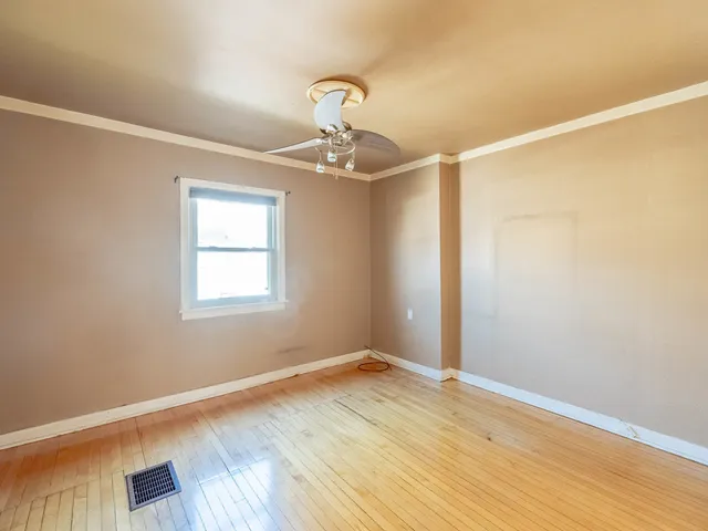 a view of a room with wooden floor fan and window