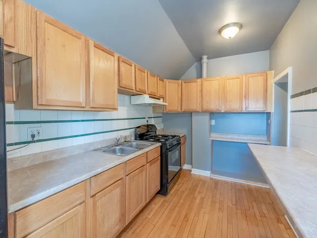 a kitchen with a sink a wooden floor and a window
