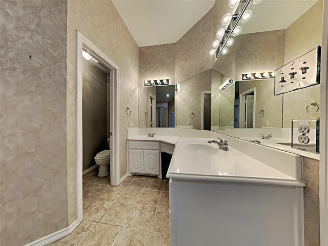a large bathroom with a double vanity sink mirror and toilet