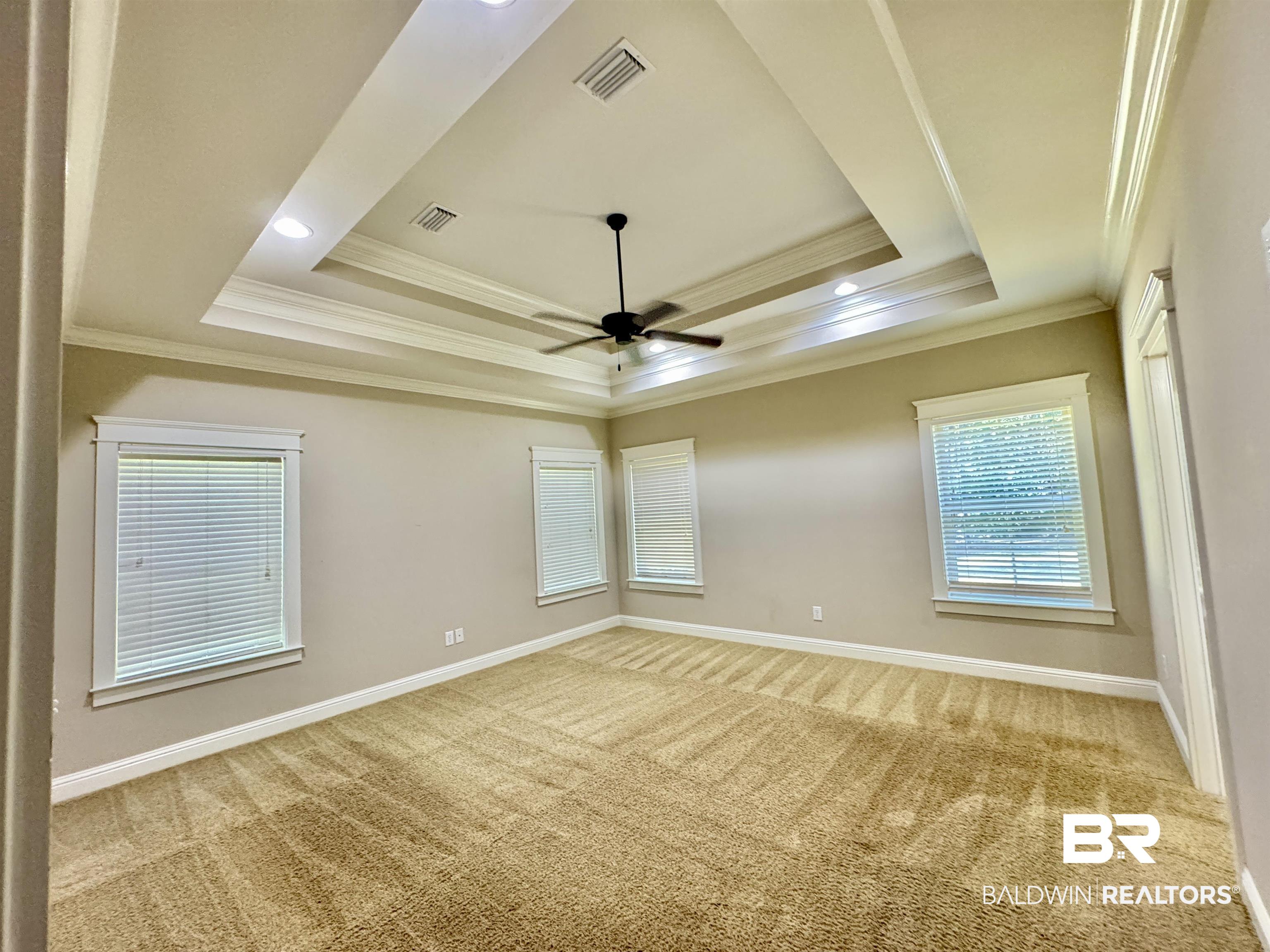 10846 County Road 138 Bay Minette, AL 36507 - Photo 50 of 53 Empty room featuring crown molding, ceiling fan, light carpet, and a raised ceiling