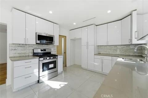a kitchen with stainless steel appliances a stove a sink and a microwave