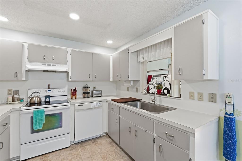 8556 Southwest 90th Lane, Unit F Ocala, FL 34481 - Photo 13 of 34 a kitchen with white cabinets sink and white appliances