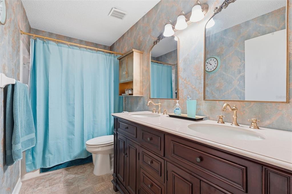 8556 Southwest 90th Lane, Unit F Ocala, FL 34481 - Photo 21 of 34 a bathroom with a double vanity sink mirror and toilet