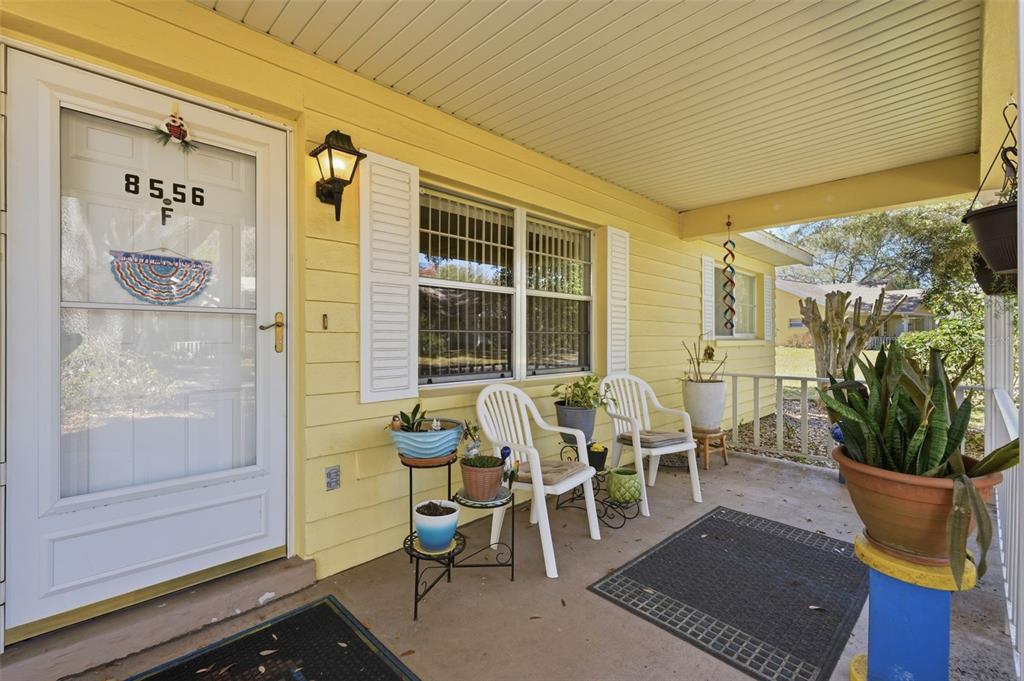 8556 Southwest 90th Lane, Unit F Ocala, FL 34481 - Photo 5 of 34 a view of a patio with table and chairs and potted plants