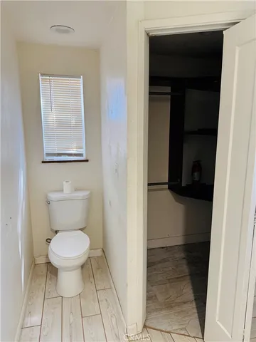 a bathroom with a toilet and a mirror