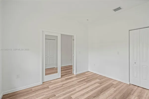 a view of wooden floor and closet in a room