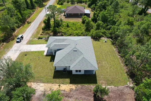 an aerial view of a house with a garden and lake view