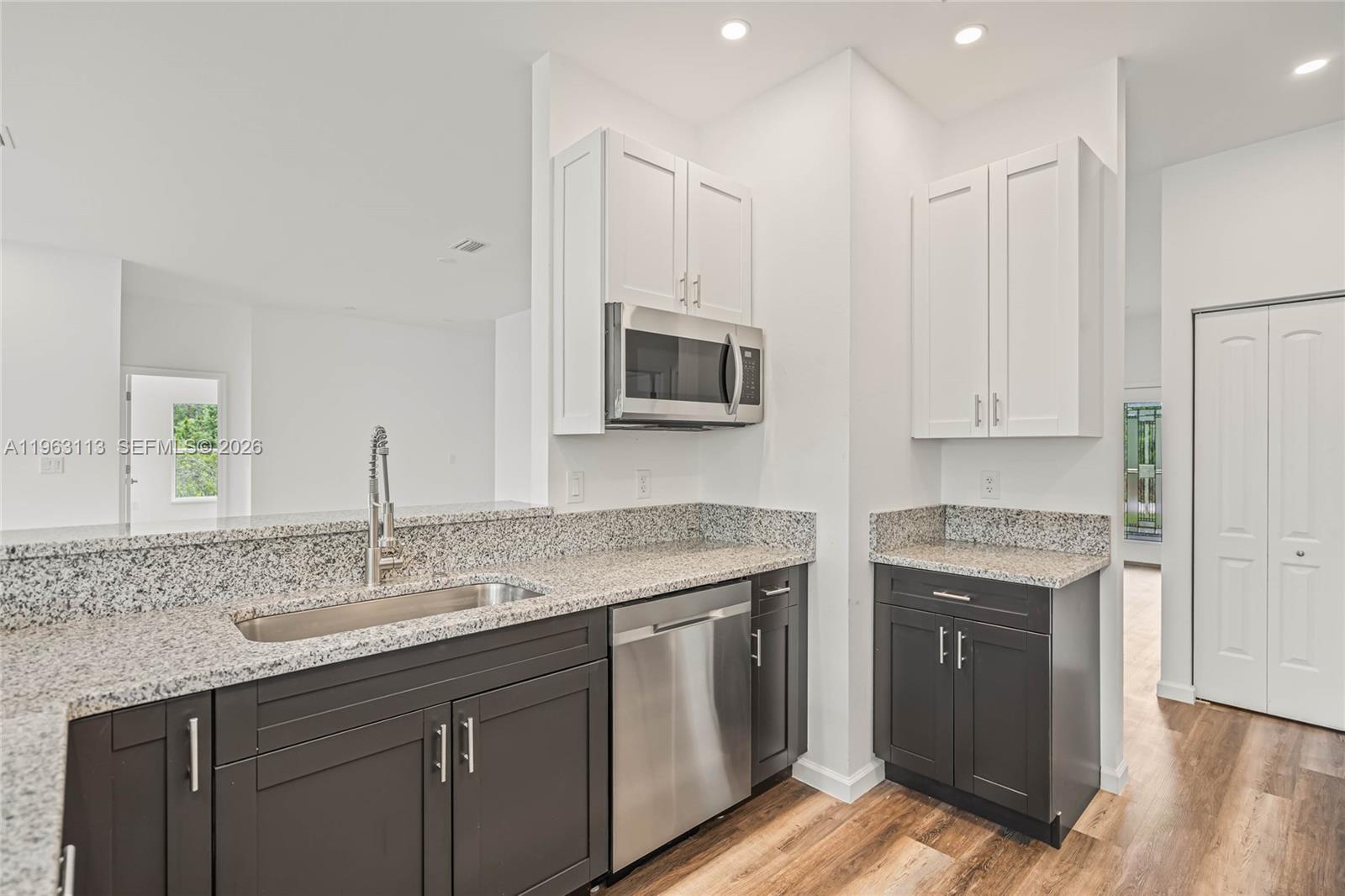 8001 Leonardo Street Sebring, FL 33872 - Photo 8 of 27 a kitchen with stainless steel appliances granite countertop a stove a sink and a microwave