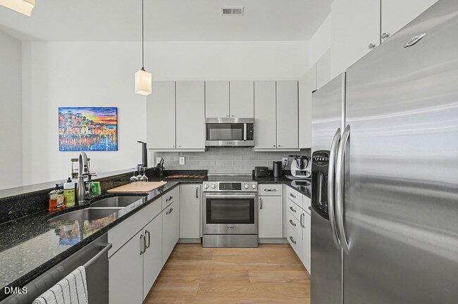103 West Main Street, Unit 305 Durham, NC 27701 - Photo 11 of 25 a kitchen with a sink stove and refrigerator