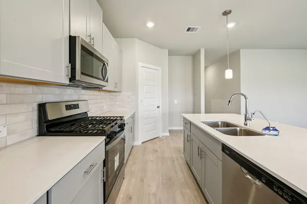 a kitchen with stainless steel appliances granite countertop a sink stove and microwave