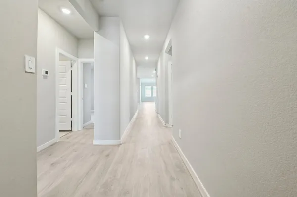 a view of a hallway with wooden floor