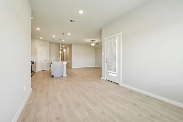 a view of an empty room with wooden floor