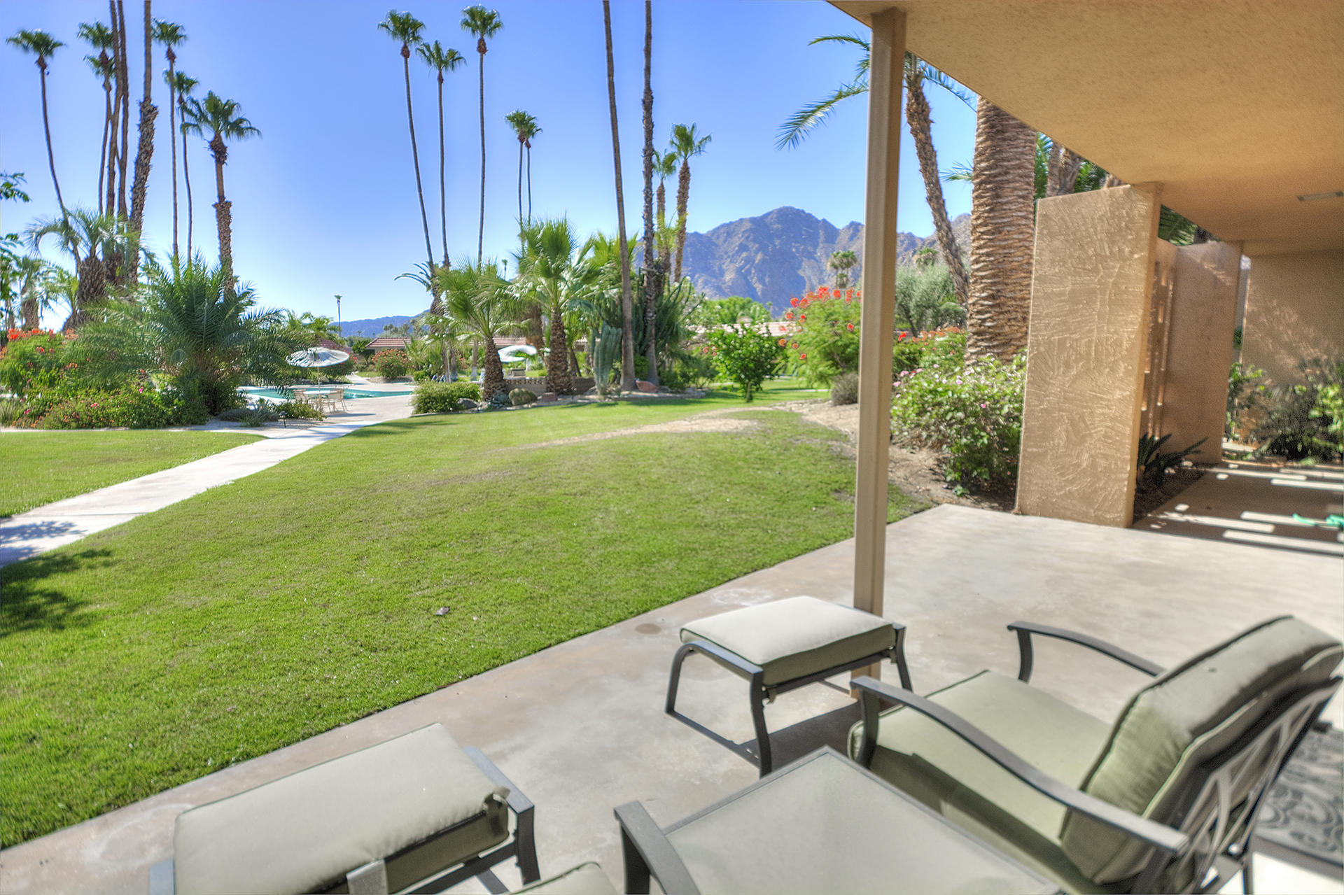 45730 Hopi Road Indian Wells, CA 92210 - Photo 32 of 42 a view of a patio with table and chairs potted plants and palm trees