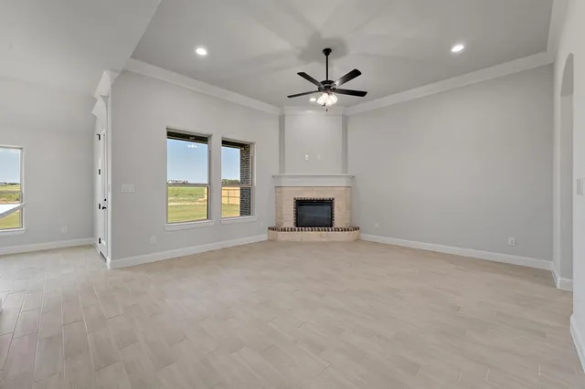 an empty room with windows and fireplace