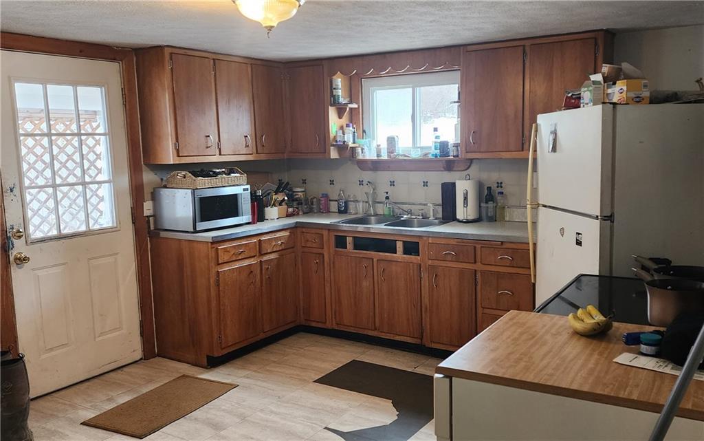 653 Sawyer Road Apollo, PA 15613 - Photo 8 of 25 a kitchen with stainless steel appliances granite countertop a refrigerator sink and wooden cabinets