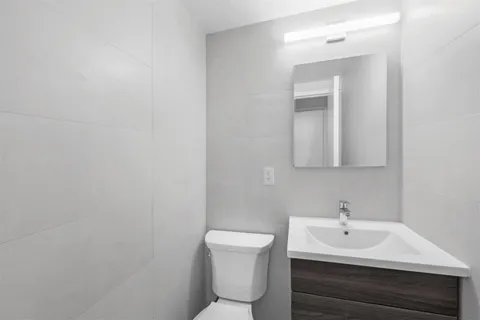 a bathroom with a sink a toilet and mirror