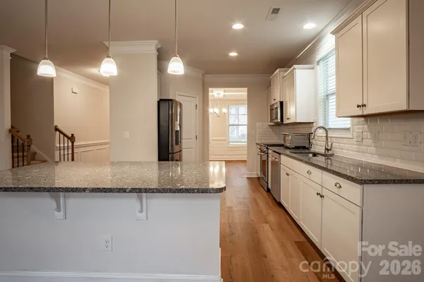 a large kitchen with granite countertop a lot of counter space and a sink