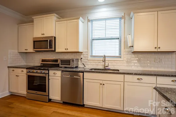 a kitchen with granite countertop cabinets stainless steel appliances and a sink