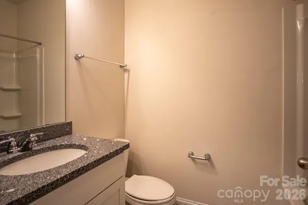 a bathroom with a granite countertop toilet sink and mirror