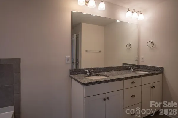 a bathroom with a granite countertop sink and a mirror