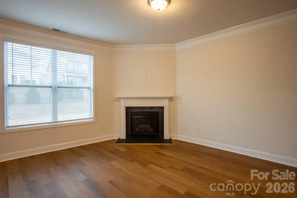 an empty room with a fireplace and windows