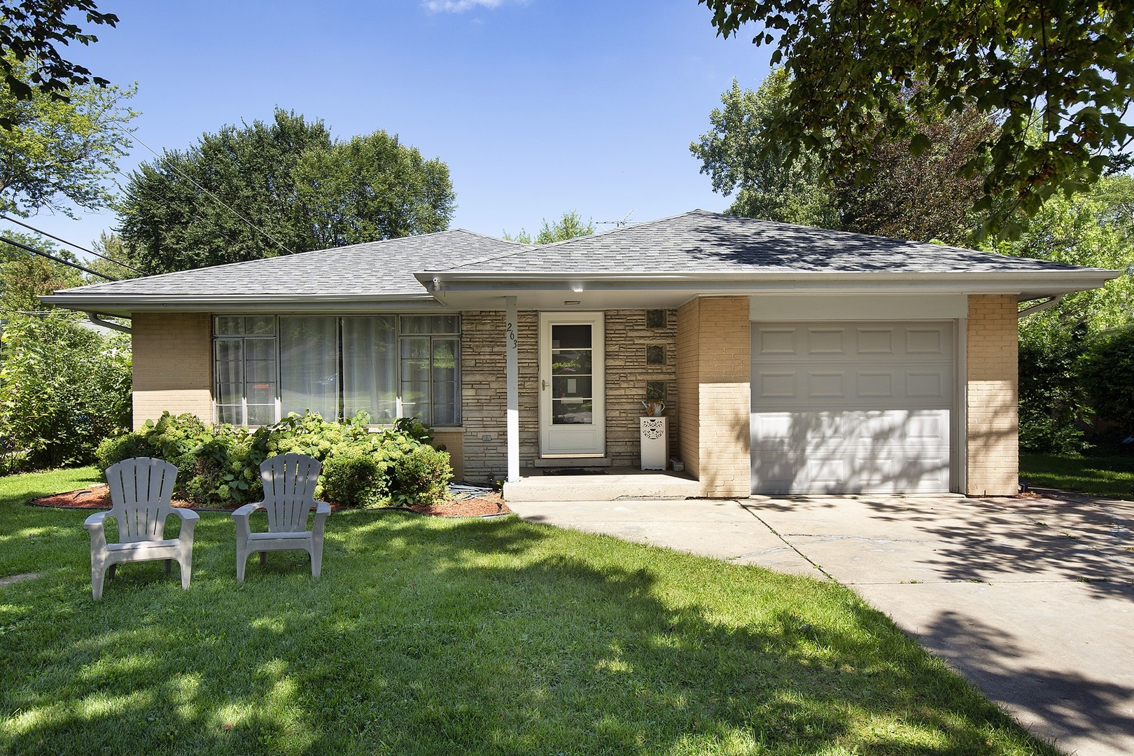 263 Riverside Drive Northfield, IL 60093 - Photo 1 of 17 a front view of a house with a garden and patio