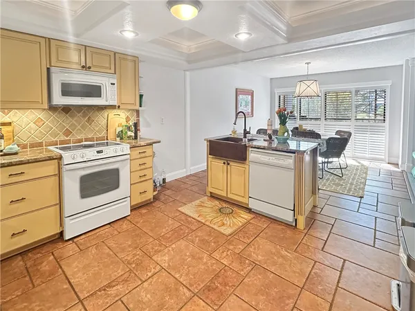 a kitchen with stainless steel appliances granite countertop a stove a sink and a microwave