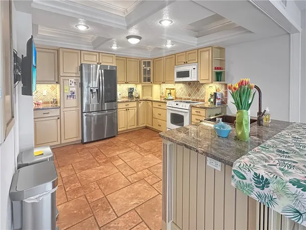a kitchen with stainless steel appliances granite countertop a refrigerator sink and stove