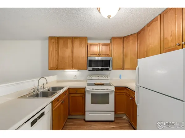 a kitchen with a sink a stove a refrigerator and cabinets