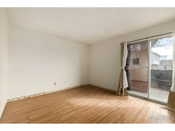 an empty room with wooden floor and door