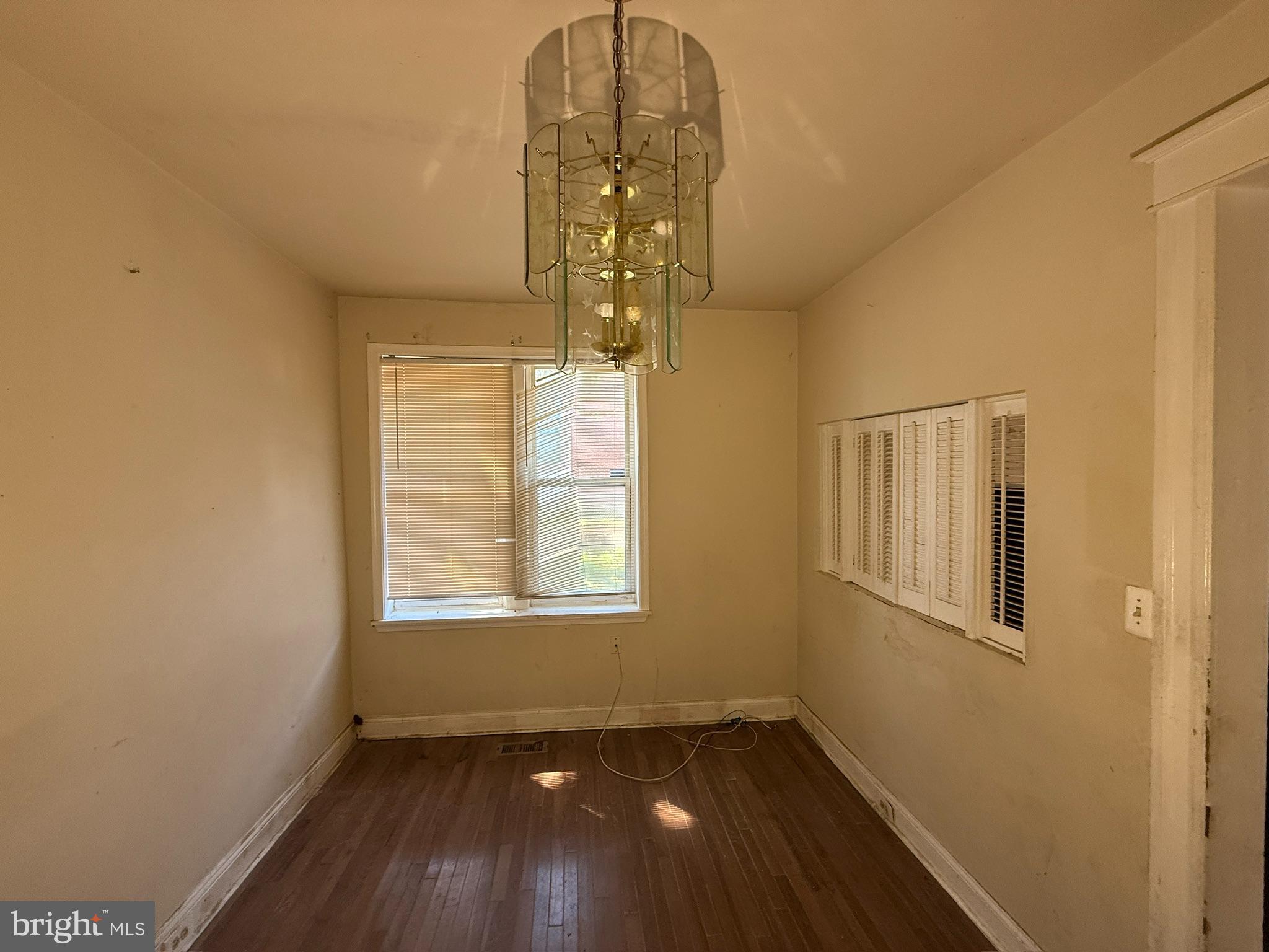 406 Edgewood Street Baltimore, MD 21229 - Photo 11 of 12 an empty room with wooden floor fan and windows