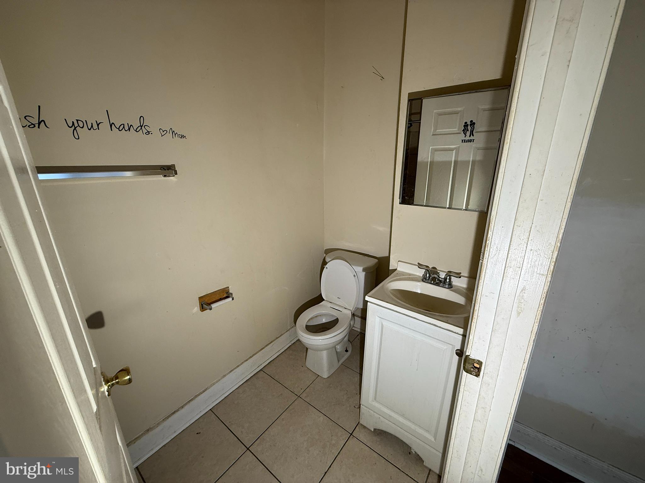 406 Edgewood Street Baltimore, MD 21229 - Photo 12 of 12 a bathroom with a granite countertop sink toilet and a mirror